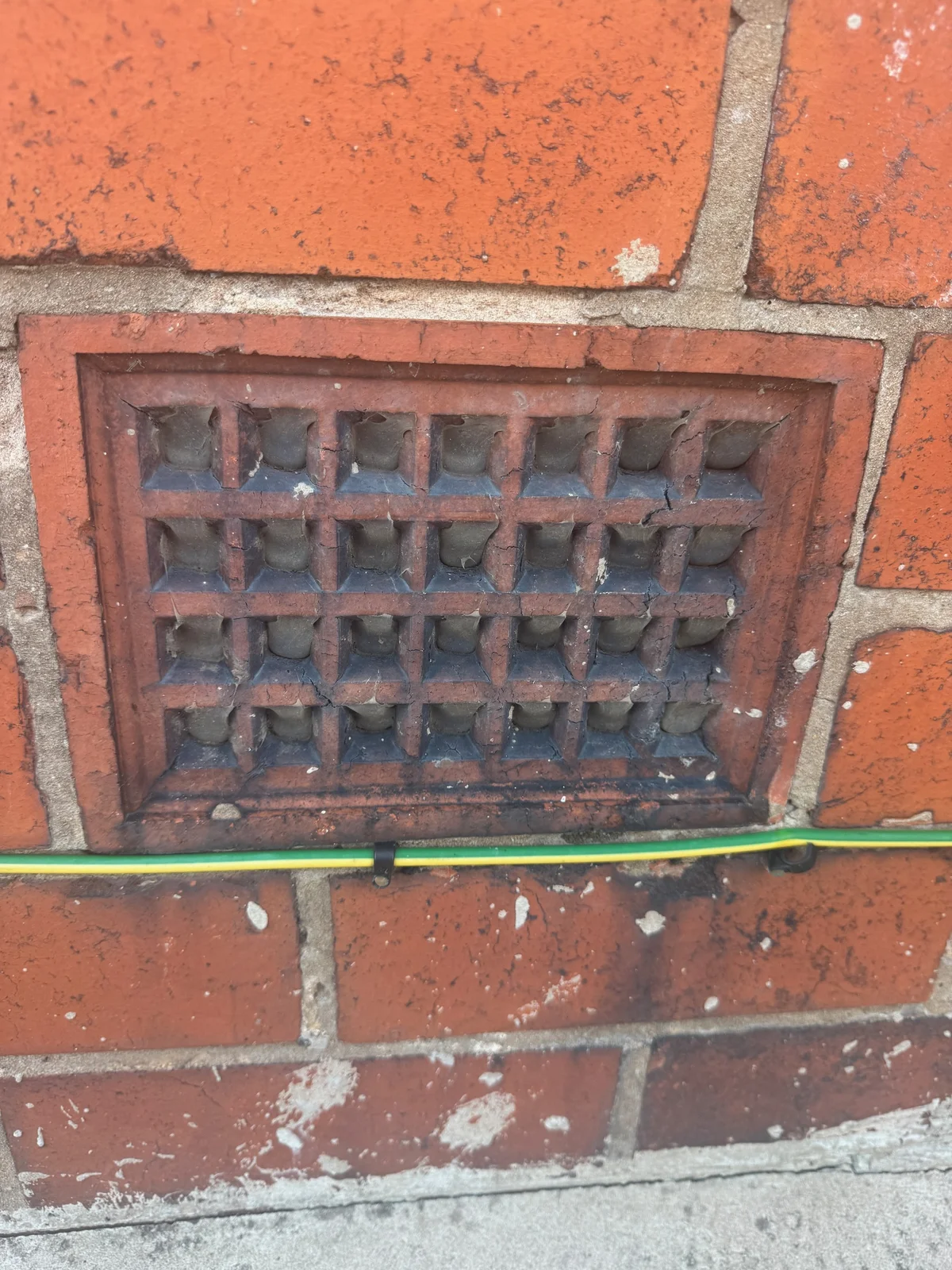 A damaged air brick with its ventilation openings visibly filled or obstructed.